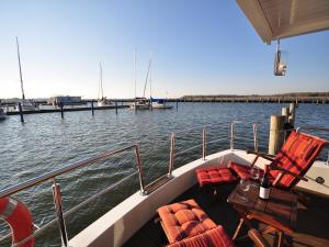 a boat with chairs and a table on the water at Hausboot Paula mit Reisekajak in Ribnitz-Damgarten in Ribnitz-Damgarten +36 photos