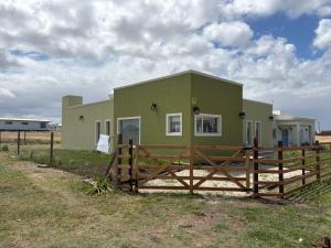 a green house with a fence in front of it at Ecos de mar in Mar del Sur