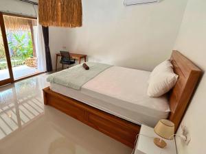 a bedroom with a bed in a room with a window at The middle Surf house in Airsatang