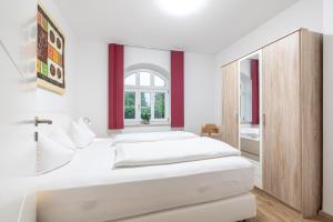 a bedroom with two beds and a mirror at Ferienwohnungen Ammerwinkel in Oberammergau