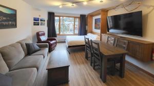 a living room with a couch and a flat screen tv at Cahilty #316 home in Sun Peaks