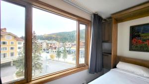a bedroom with a large window with a view at Cahilty #316 home in Sun Peaks