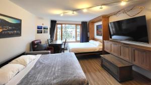 a hotel room with a bed and a flat screen tv at Cahilty #316 home in Sun Peaks