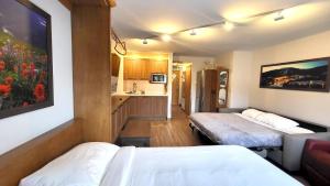 a hotel room with two beds and a kitchen at Cahilty #316 home in Sun Peaks