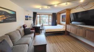 a living room with a couch and a flat screen tv at Cahilty #316 home in Sun Peaks +8 photos