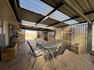 a dining room with a glass table and chairs at Southern Comfort in Esperance in Esperance