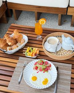 a table with a breakfast of eggs and bread and juice at Aerys Village in Somone