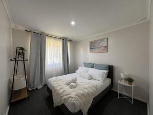 a bedroom with a bed with a teddy bear on it at Southern Comfort in Esperance in Esperance