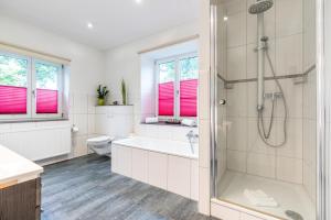 a bathroom with a shower and a tub and a toilet at Ferienwohnungen Ammerwinkel in Oberammergau +11 photos