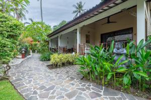 ein Haus mit einem steinernen Gehweg davor in der Unterkunft Puri Mas Boutique Resort & Spa in Senggigi 