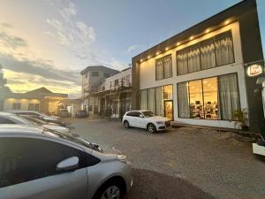a parking lot with cars parked in front of a building at Colony Stay in Paramaribo