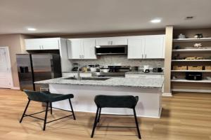 a kitchen with white cabinets and a counter and two chairs at The Blue Venue-Periwinkle in Clarksville +2 photos