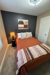 a bedroom with a bed with an orange blanket at The Blue Venue-Periwinkle in Clarksville