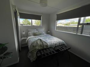 a bedroom with a bed and two windows at Relax at Jollie-Cozy 3-Bedroom Home, Central Twizel in Twizel +21 photos