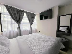 a bedroom with a white bed and a window at Hotel Monaco in Ipiales