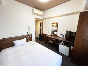 a hotel room with a bed and a desk at Hotel Route-Inn Shin Gotemba Inter -Kokudo 246 gou- in Gotemba