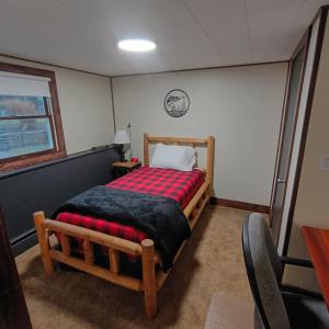 a bedroom with a wooden bed with a red blanket at Cliffside Cottage in Mansfield