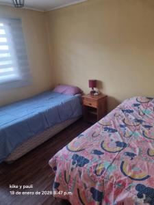 a bedroom with two beds and a night stand with a bedskirts at Cabaña Quillaycillo in La Rudilla