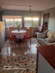 a living room with a table and chairs and a couch at Cabaña Quillaycillo in La Rudilla