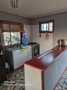a kitchen with a sink and a stove top oven at Cabaña Quillaycillo in La Rudilla