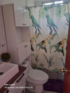 a bathroom with a shower curtain with birds on it at Cabaña Quillaycillo in La Rudilla