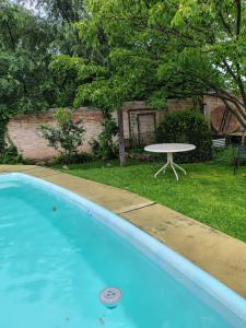 a blue swimming pool with a table in the yard at Garden Atelier Eco Friendly in La Cumbre
