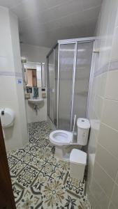 a bathroom with a shower and a toilet and a sink at Hotel Imperial in Chiquinquirá +92 photos