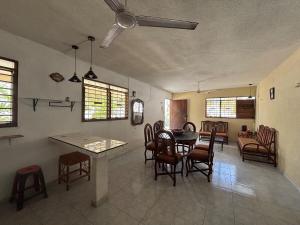 a living room with a dining room table and chairs at House 30 meters from the sea in Chicxulub