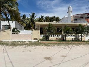 a white house with palm trees in front of it at House 30 meters from the sea in Chicxulub