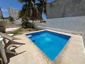 a small blue swimming pool next to a building at House 30 meters from the sea in Chicxulub