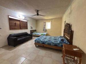 a living room with a bed and a couch at House 30 meters from the sea in Chicxulub +16 photos