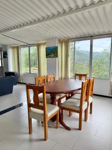 a dining room with a wooden table and chairs at Casa Sué Soatá in Soatá