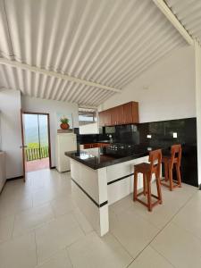 a kitchen with black counter tops and wooden chairs at Casa Sué Soatá in Soatá