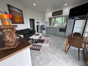 a kitchen and living room with a couch and a table at Taipa Coastal Retreat in Taipa