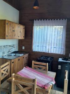 a kitchen with a table and a stove and a window at ResidencialBambu2 in Garopaba