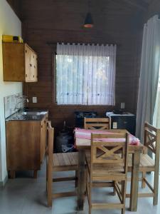a kitchen with a table and chairs and a window at ResidencialBambu2 in Garopaba +4 photos