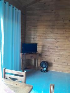 a room with a desk with a computer and a blue curtain at ResidencialBambu2 in Garopaba