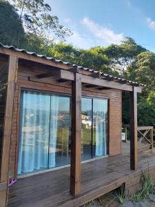 a cabin with a deck with a view of the water at ResidencialBambu2 in Garopaba