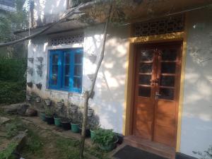 a house with a blue window and a door at Sehandi Hotels - Renaissance Ella in Ella