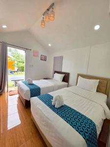 a bedroom with two beds and a window at บลูคริสตัลรีสอร์ทแหลมสิงห์ in Laem Sing +42 photos