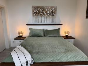 a bedroom with a green bed with two night stands at Taipa Coastal Retreat in Taipa