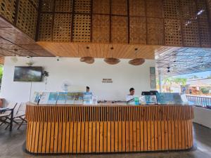 a restaurant with a wooden counter with two people behind it at Treeshade Resort & Spa Moalboal in Moalboal