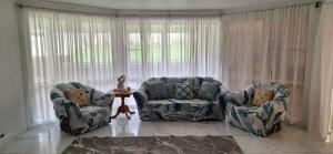 two chairs and a couch in a living room at Aeris Holiday Home Flinders NSW Pet Friendly in Croom