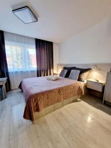 a bedroom with a bed and a large window at Angel in Kołobrzeg