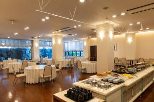 a banquet hall with tables and chairs in a room at ホテルグランフォーレ in Shikokuchuo