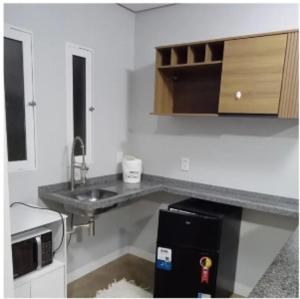 a kitchen with a sink and a small refrigerator at Hotel Mercosul in Butiá