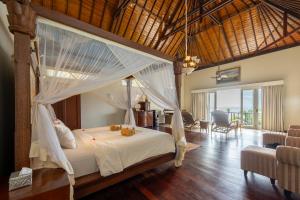 ein Schlafzimmer mit einem Himmelbett in der Unterkunft Puri Mas Boutique Resort & Spa in Senggigi  + 121 Fotos
