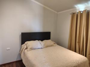a bed with a black headboard in a bedroom at Maravillas de Tongoy in Tongoy