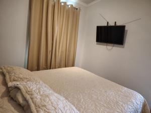 a bedroom with a bed and a television on the wall at Maravillas de Tongoy in Tongoy