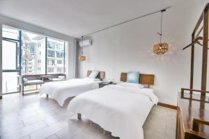 two beds in a room with a large window at Morning Sun Hotel in Yangshuo +27 photos